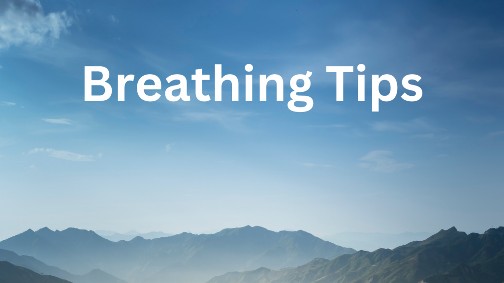A photo of the sky and the top of a mountain range. The sky is blue with light clouds. The words "Breathing Tips" is over the blue sky in white writing.