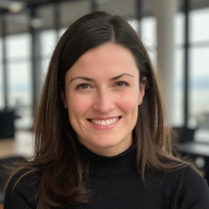 A woman with long brown hair smiles at the camera.